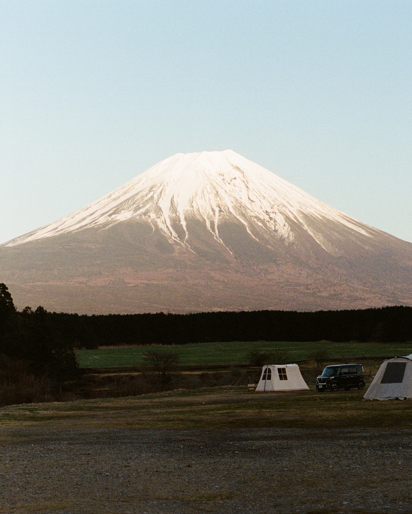 Mount Fuji at dusk with campsite tents in the foreground